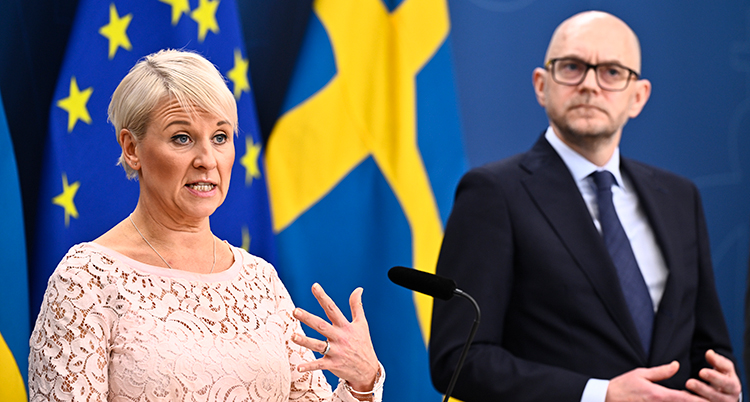 De står framför mikrofoner och pratar.