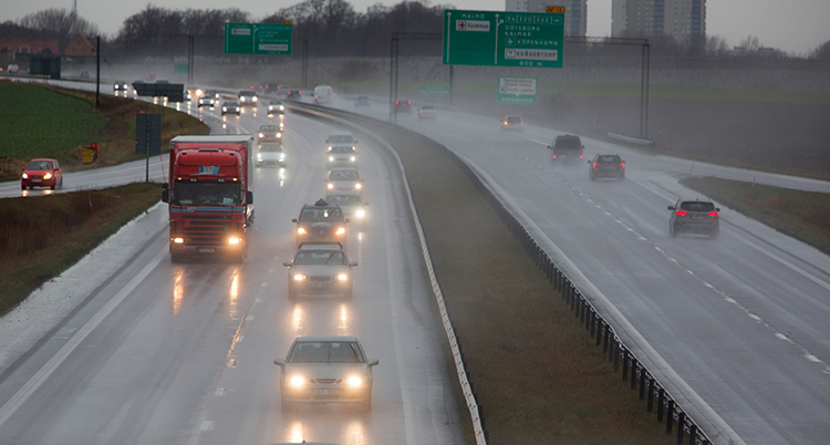 Bilar på en regnig stor väg.