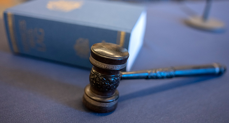 En klubba ligger framför boken med lagar.