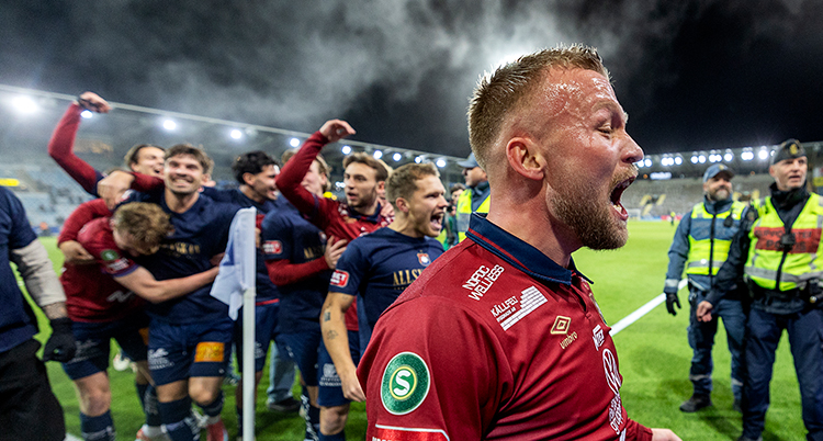 Han skriker. Bakom står hans lagkamrater.