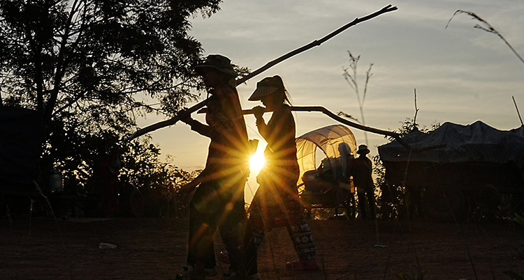 Två människor går. Solen går ned i bakgrunden.