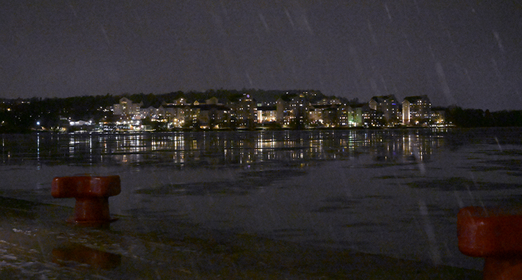 Det är mörkt ute. Tända lampor i hus lyser.