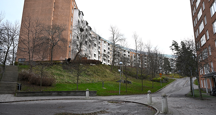 En plats för att vända med bilar vid ett stort hus med flera lägenheter.