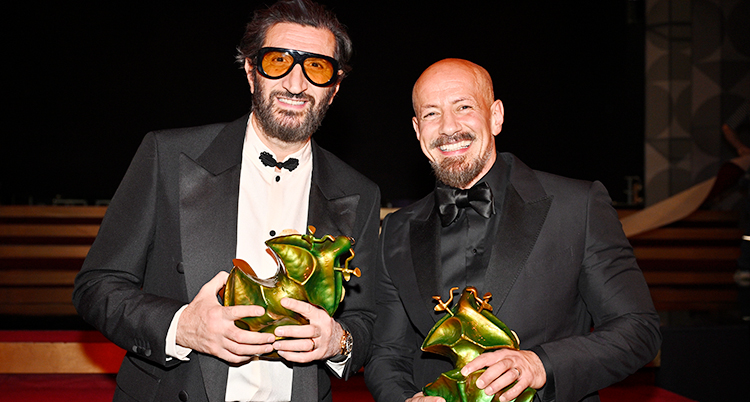 De står bredvid varandra och tittar in i kameran. De är glada. De har fina kläder. De håller i varsin Guldbagge.