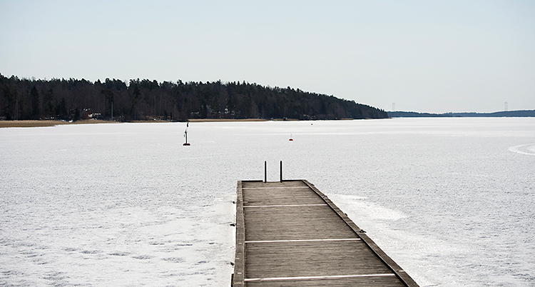 En brygga vid en sjö som är täckt av is.