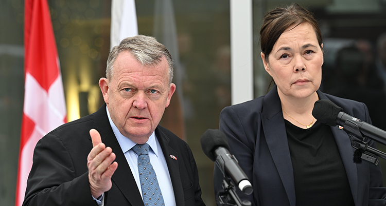 De står bakom en mikrofon och pratar.