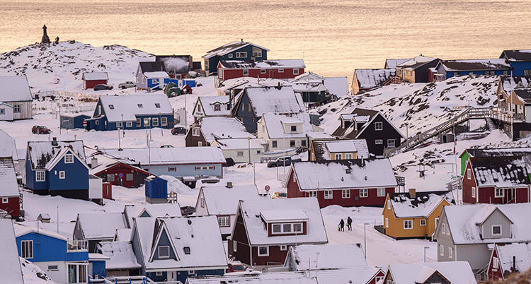 Flera hus i olika färger. Snö ligger på taken.
