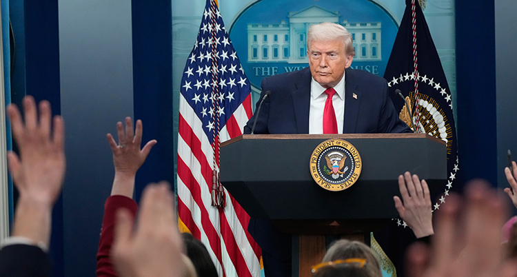 Trump står på en scen framför en mikrofon.