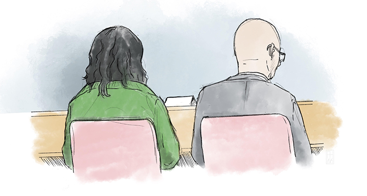 Två personer sitter på stolar. Deras ryggar syns.