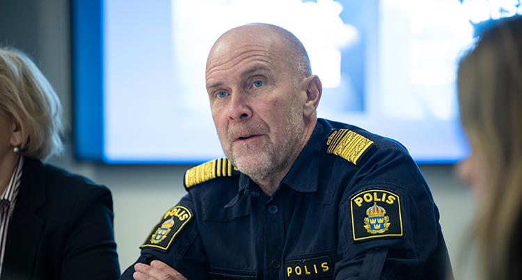 En svensk polis som sitter ner.