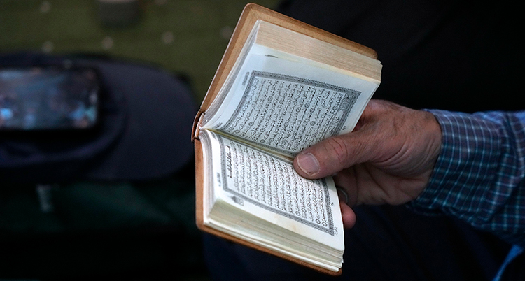 En person håller i en bok med mycket text.