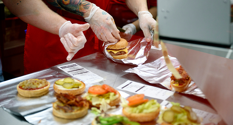 Människor lagar hamburgare.