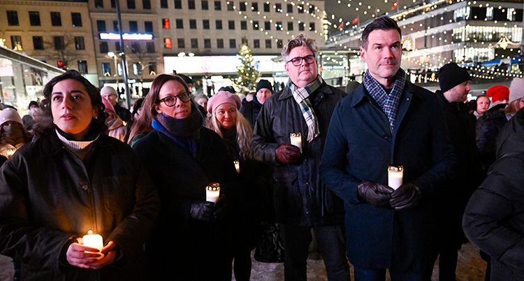 De står ute med tända ljus.