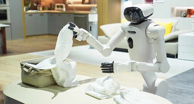 En robot står vi en bänk och viker tvätt.