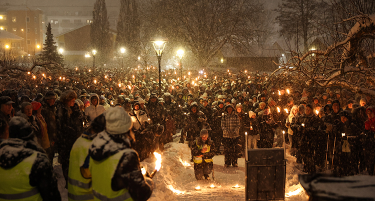Många människor och tända ljus.