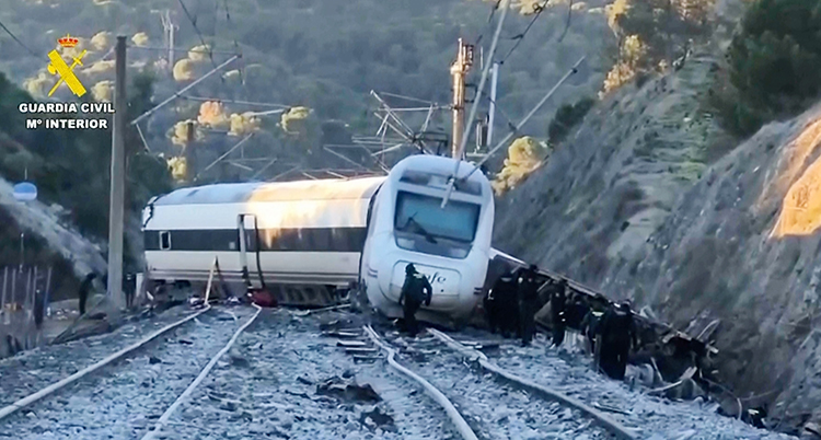 Ett tåg som krockat och åkt av spåret. En vagn ligger ner.