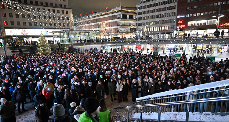 Många människor står på torget.