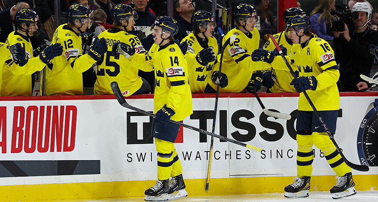 Två spelare åker på isen och hälsar på de andra spelarna i laget.