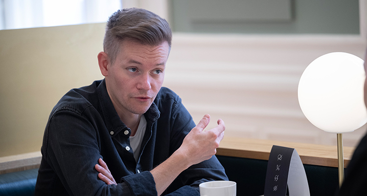 Han sitter vid ett bord.