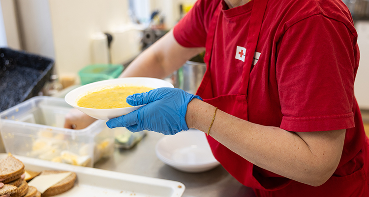 Personal håller en skål med soppa.