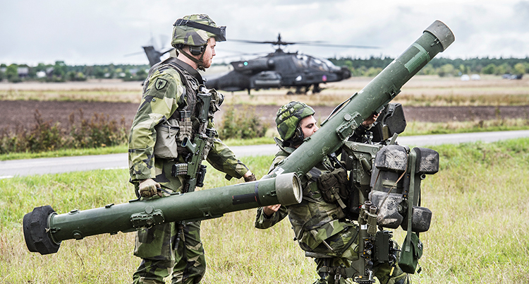 Två militärer håller i stora vapen som kan skjuta raketer.