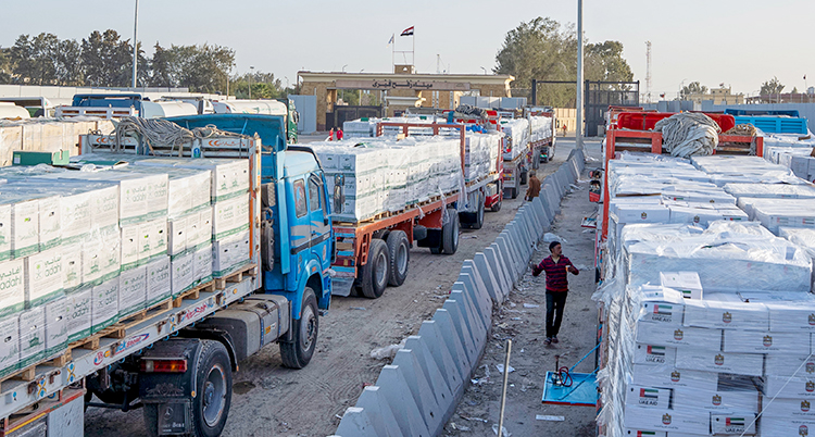 Massor av lastbilar som står vid gränsen till området Gaza. Lastbilarna har lådor på sina släp.