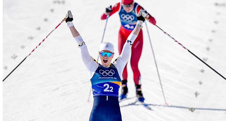 En tävling i skidor. Maja Dahlqvist går i mål. Hon jublar och sträcker armarna i luften.