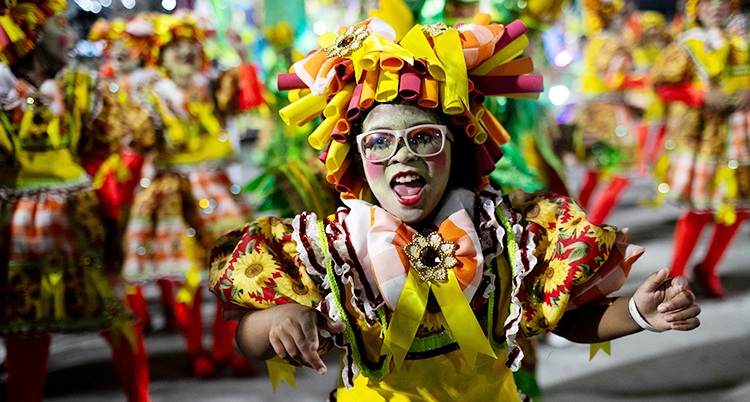 Det är karneval. En person som dansar i färgglada kläder.