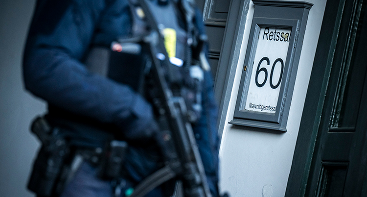 En polis håller i ett stort vapen.