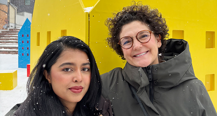 Två kvinnor står bredvid varandra. De tittar in i kameran.