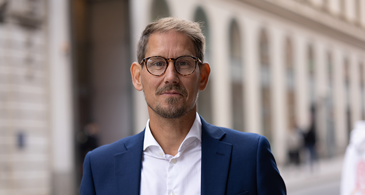 Han har glasögon och mustasch.