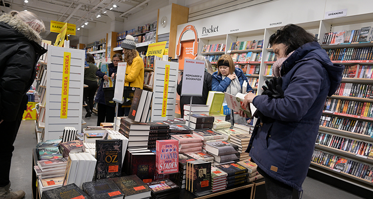 Människor går runt i en bokaffär och tittar när det är rea.