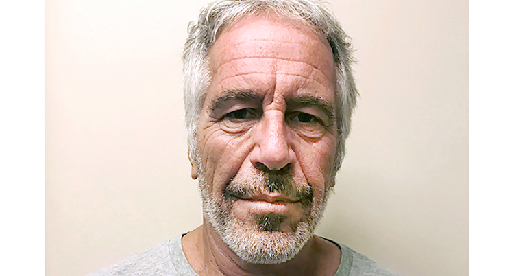 En närbild på hans ansikte. Han tittar in i kameran. Han har grått hår och lite skägg.
