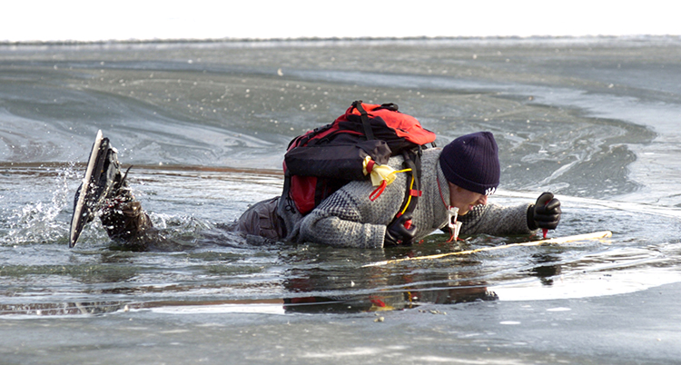 Han ligger i vattnet och han har isdubbar i händerna.