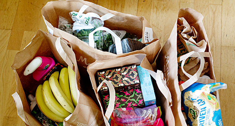 Flera kassar med mat står på ett golv.