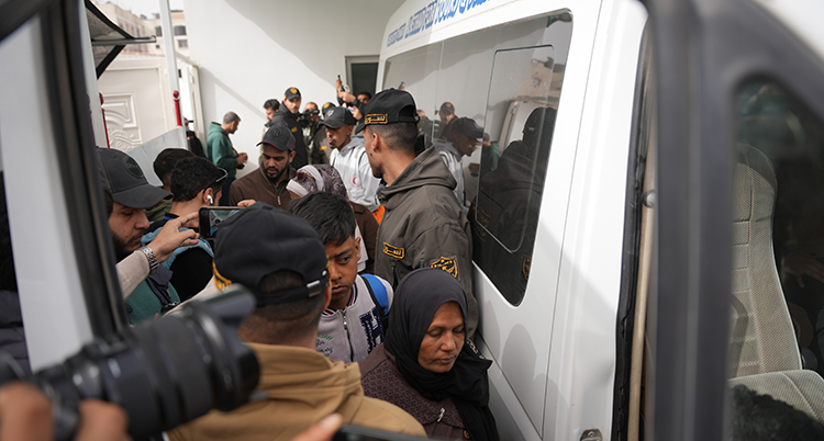 Många människor står vid en bil.