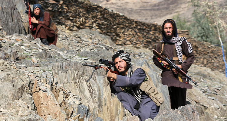 Tre soldater med gevär gömmer sig i ett berg.