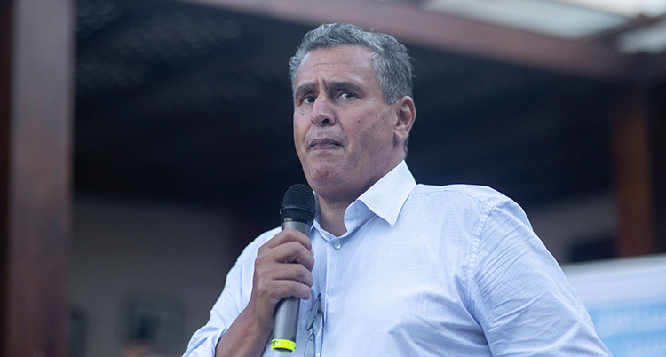 Han pratar i en mikrofon.