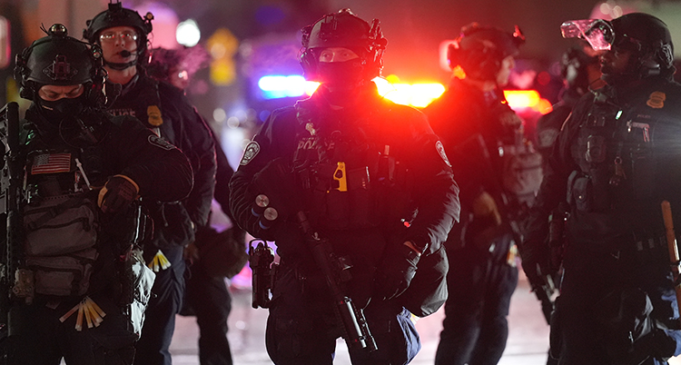 Poliser med militärkläder och vapen.