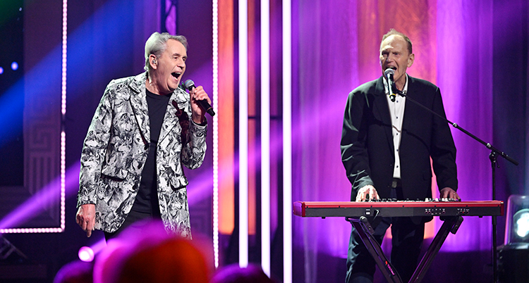 Två män står på en scen och sjunger.