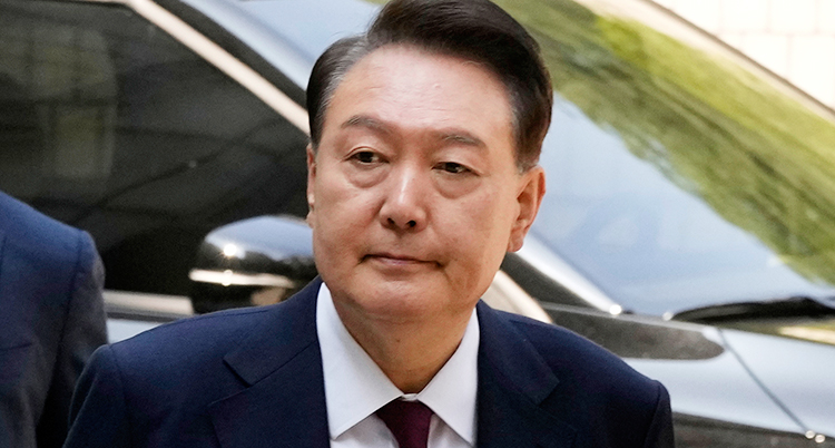 En närbild på honom. Han har mörkt hår, kostym och slips.