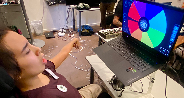 Hon sitter framför en dator. I datorn syns en cirkel med olika färger.