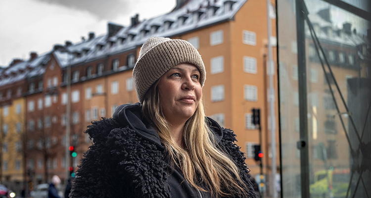 Hon har mössa och långt hår.