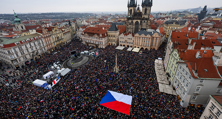 Ett torg är fyllt av människor. Några håller i Tjeckiens flagga.