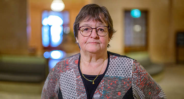 Hon ser allvarlig ut. Hon tittar in i kameran.