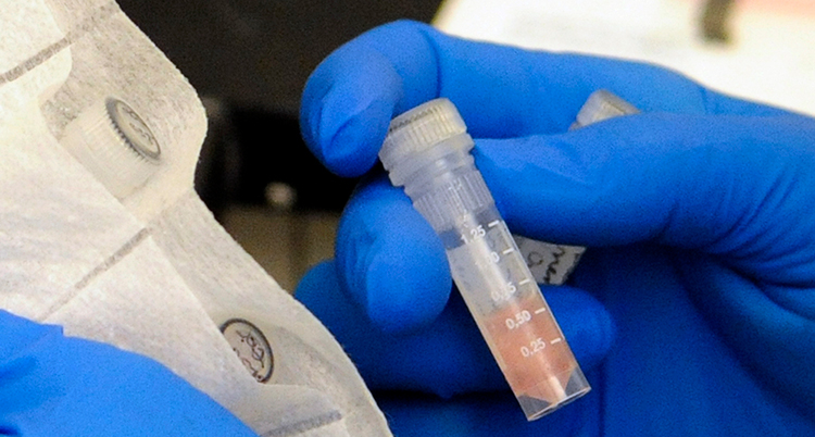 En person håller i rör. Personen har handskar på sig.