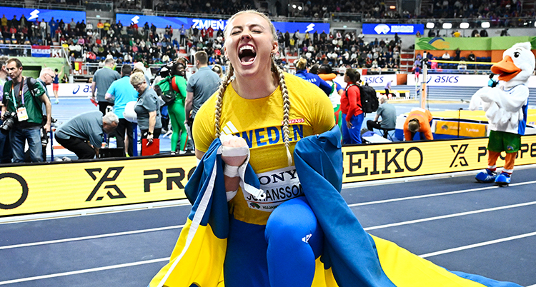 Hon har Sveriges flagga runt sig. Hon jublar.