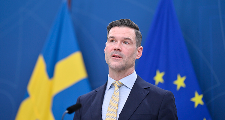 Han står och pratar på en träff med journalister.