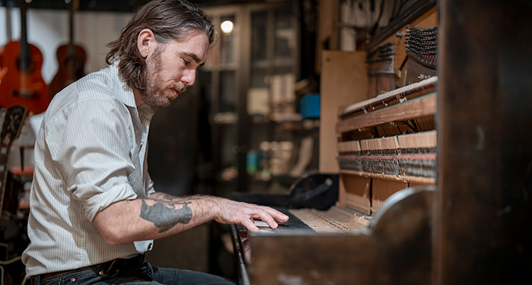 Han sitter och spelar piano.