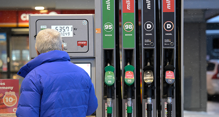 En person står vid pumpen vid en bensinmack.